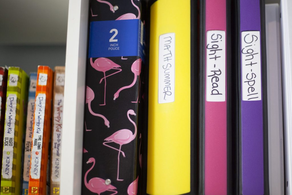 Student program binders at Novaread labelled Sight-Read, Sight-Spell and Math Summer on a shelf