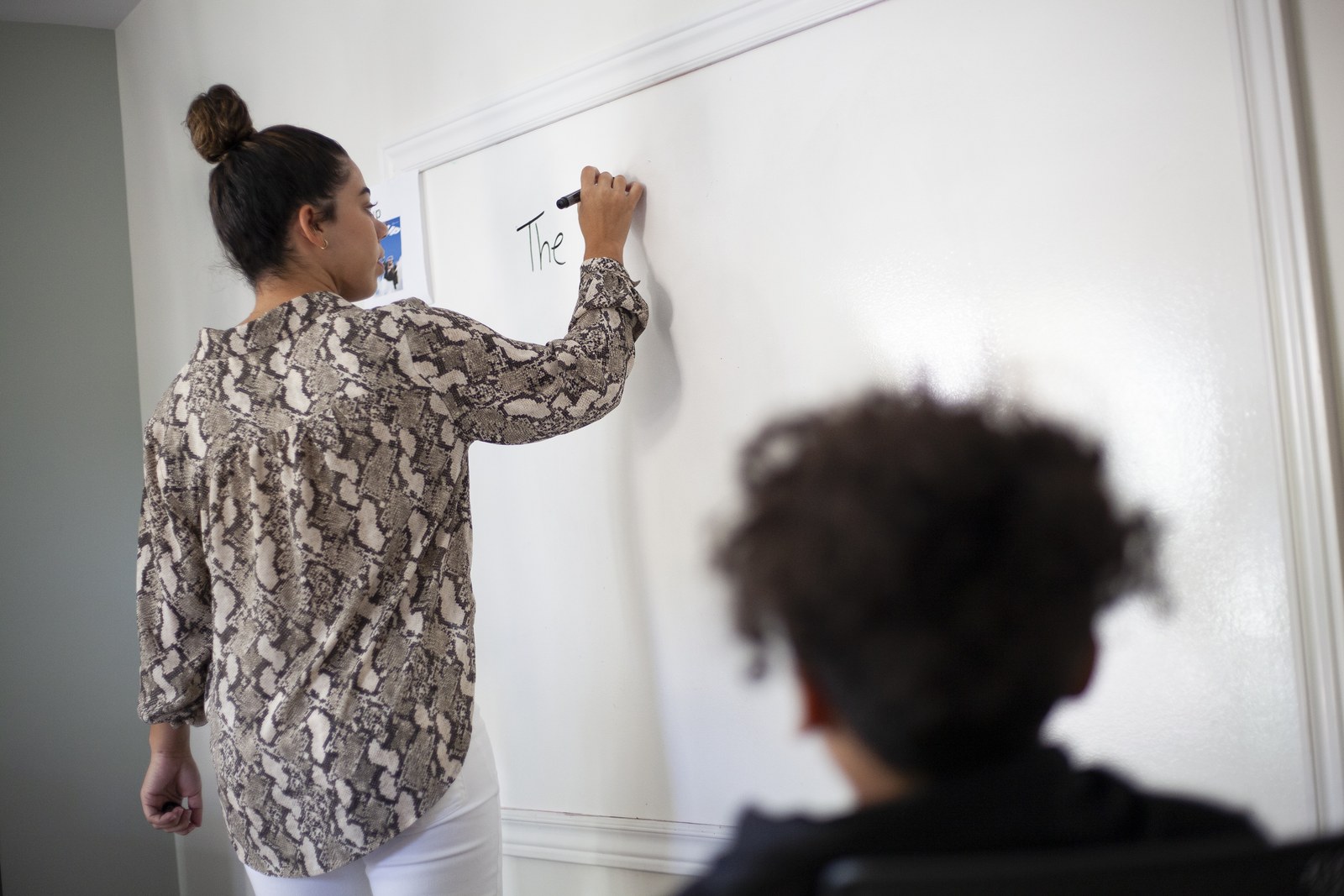 Student writing on a whiteboard during a Novaread session